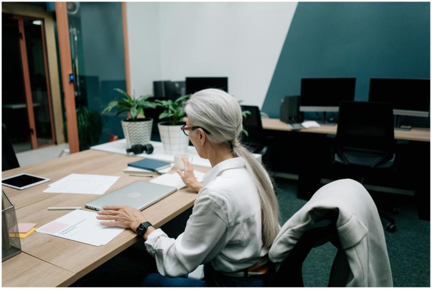 Senior woman with gray hair working at a laptop in