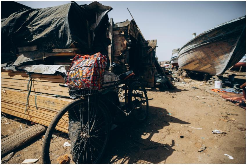A vintage bicycle amidst wooden boats and market s