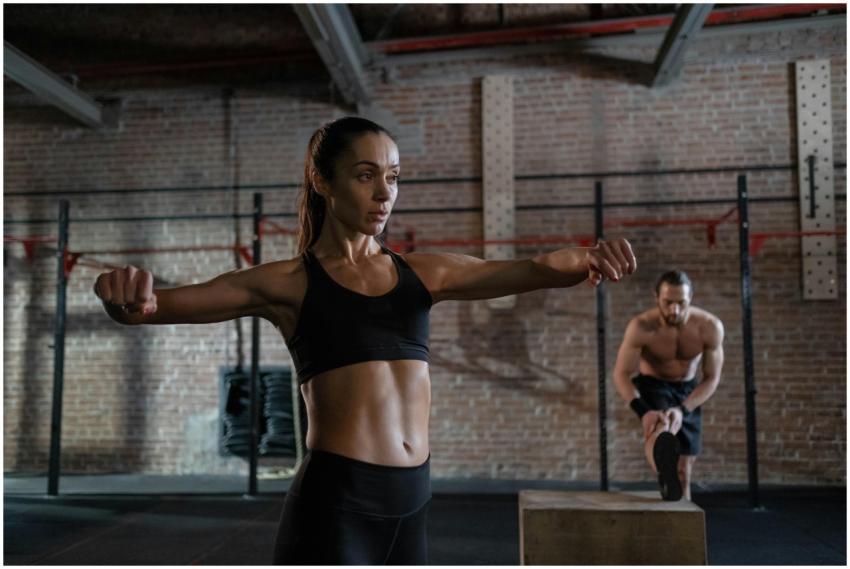 Two athletes workout indoors, engaging in focused