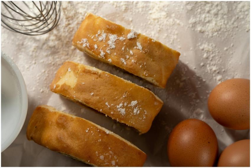 Close-up of fresh cake slices with eggs and flour,