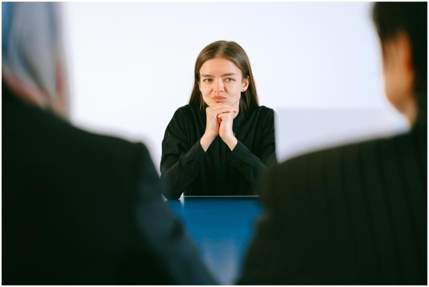 A woman in a job interview facing two people at an