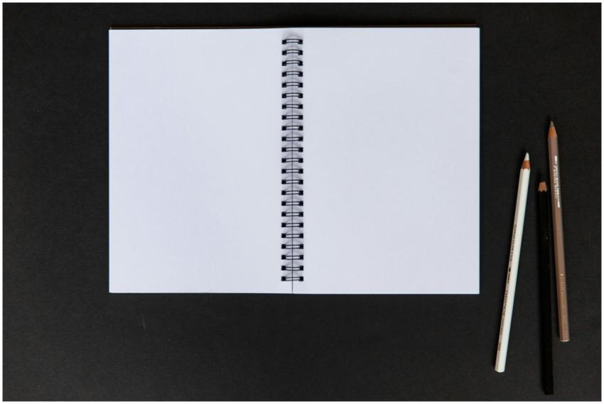 Close-up of an open notebook with color pencils on