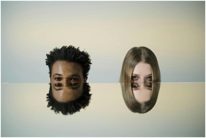 Two faces mirrored on a smooth surface creating a