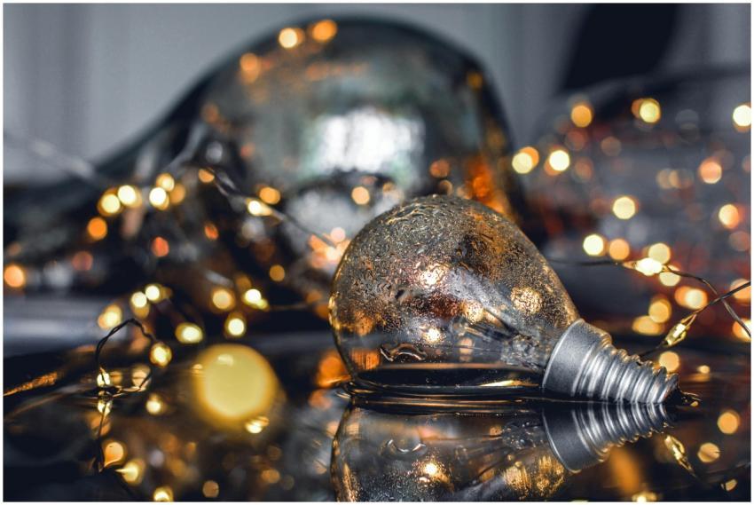 Close-up of wet light bulbs and fairy lights refle