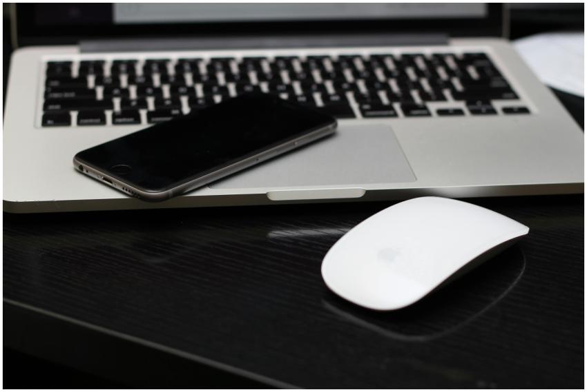 A sleek workspace featuring a laptop, smartphone,