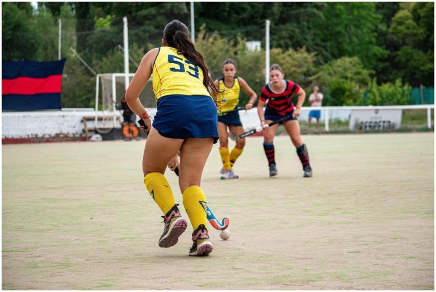 Field hockey players in action on outdoor turf dur
