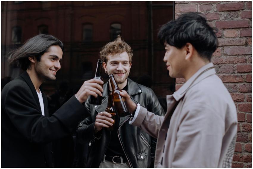 Three young men sharing a joyful moment while toas
