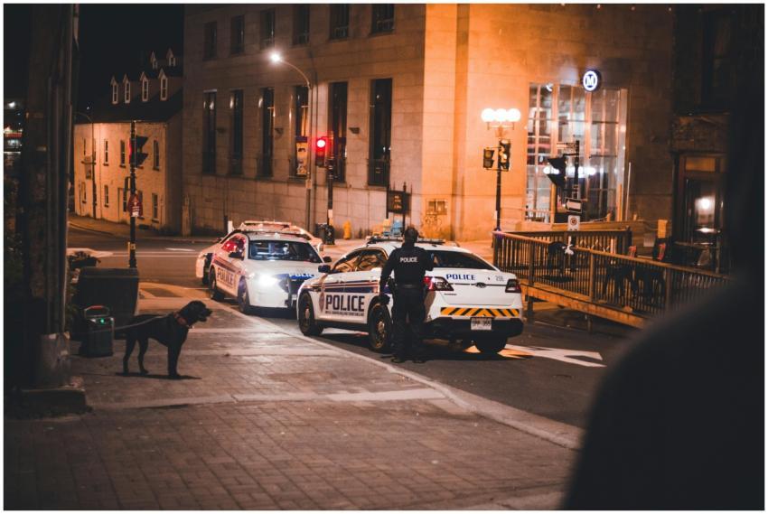 Police cars and officers in an urban street at nig