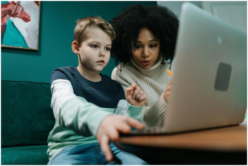 A woman and child using a laptop together indoors,