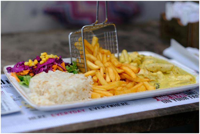 Close-up of a meal with rice, fries, and vibrant s