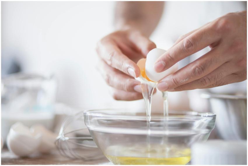 Hands carefully separating egg yolks and whites in