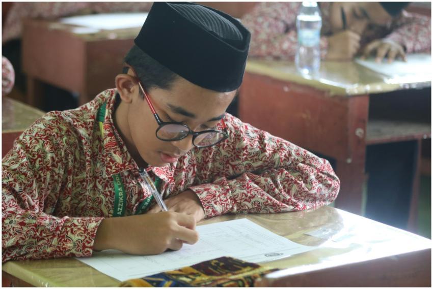 A diligent schoolboy wearing traditional clothing