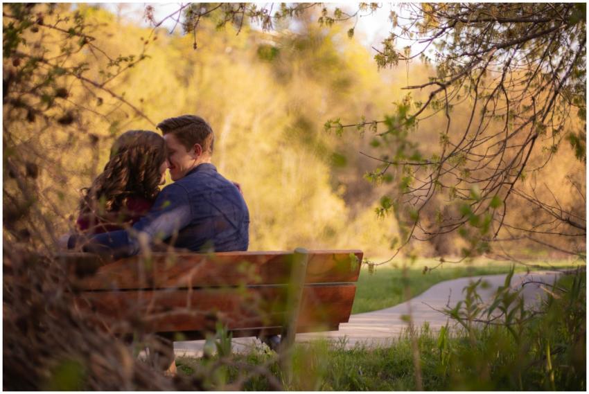 A couple enjoying a cozy moment on a park bench su