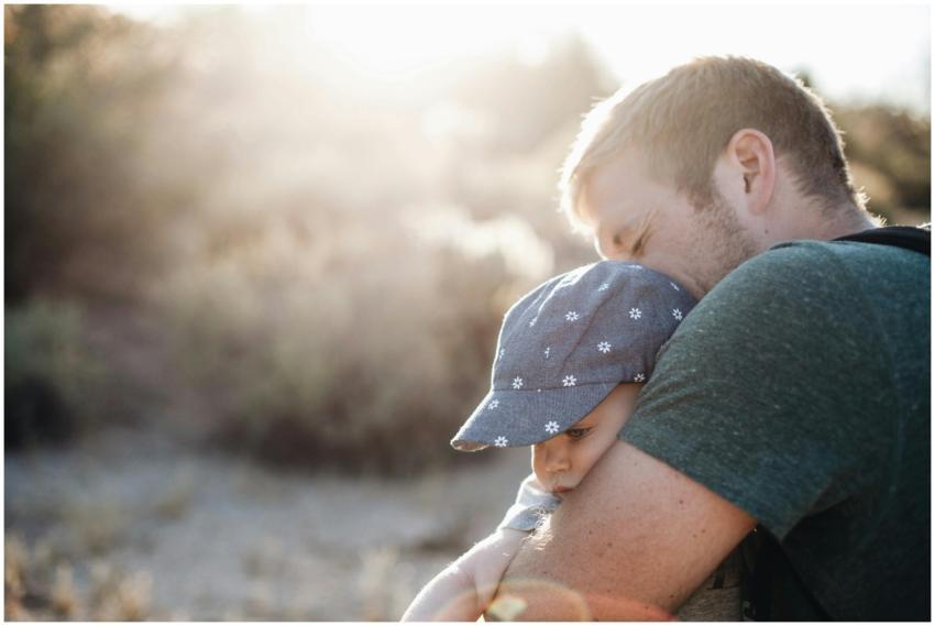 A father lovingly embraces his baby outdoors on a