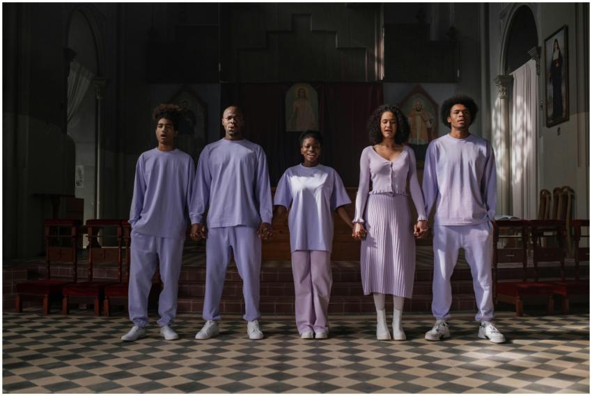 Group of five people in pastel attire standing in