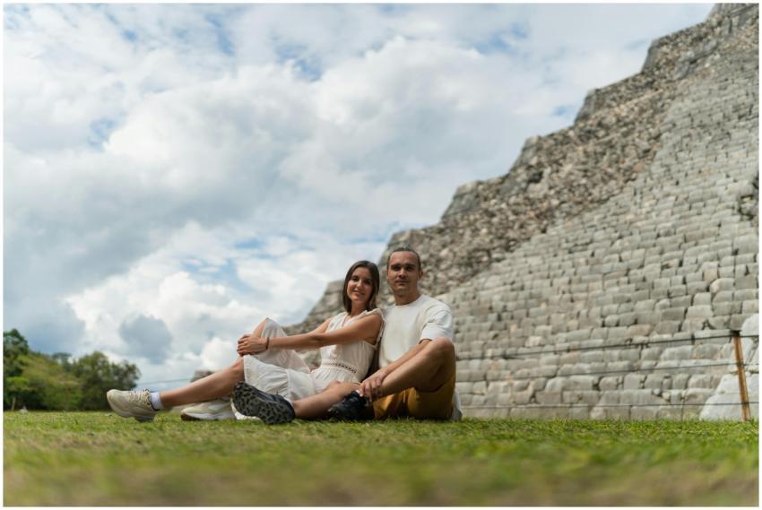 Happy couple sitting near ancient Mayan pyramid in