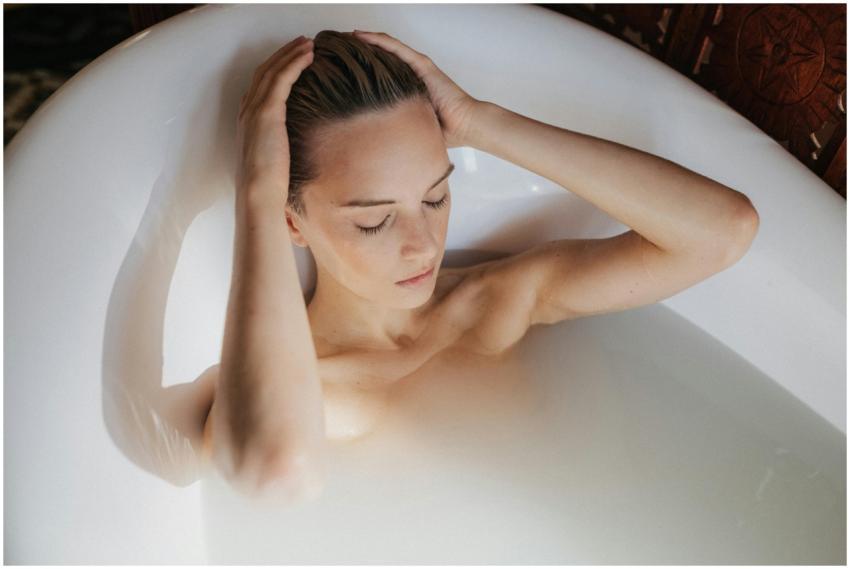 Woman relaxing in a milk bath with eyes closed and