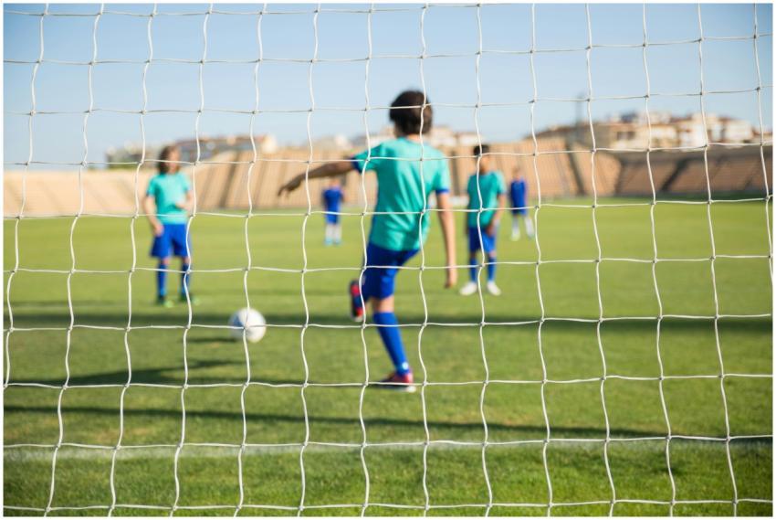 Group of children playing soccer on a sunny day in