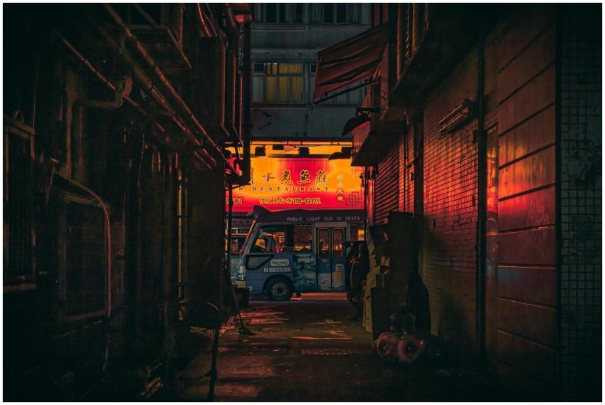 Urban alley in Hong Kong featuring vibrant neon si