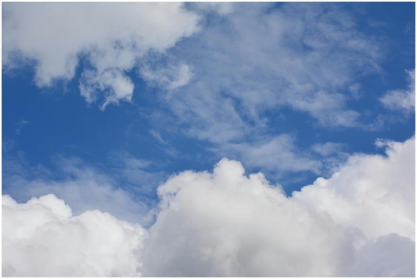 Cumulus clouds against a bright blue sky create a