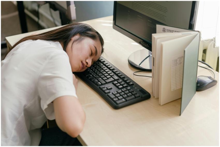 Young woman student asleep on a computer keyboard
