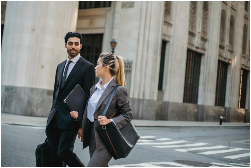 Two business professionals walking outdoors, weari
