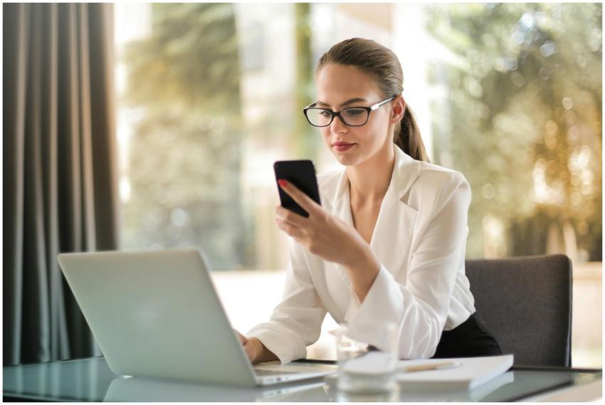 Professional woman using smartphone while working