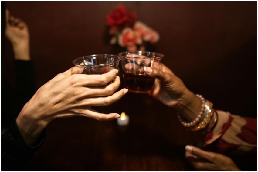 Two women toasting with drinks in a cozy bar setti