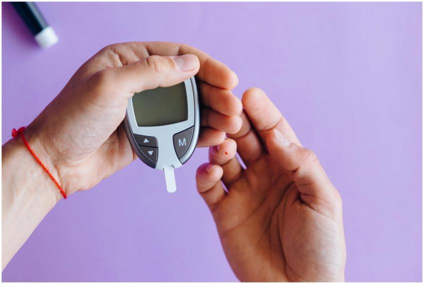 Hands holding a glucometer to test blood sugar lev