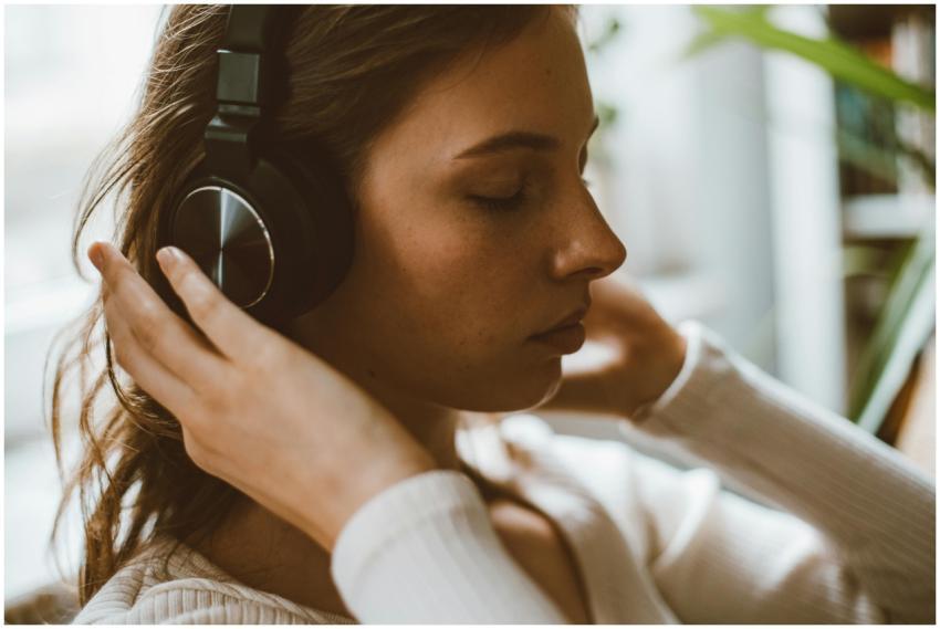 Side profile of a woman with headphones relaxing i
