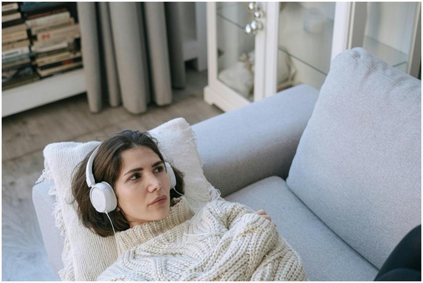 Young woman wearing headphones and knitted sweater