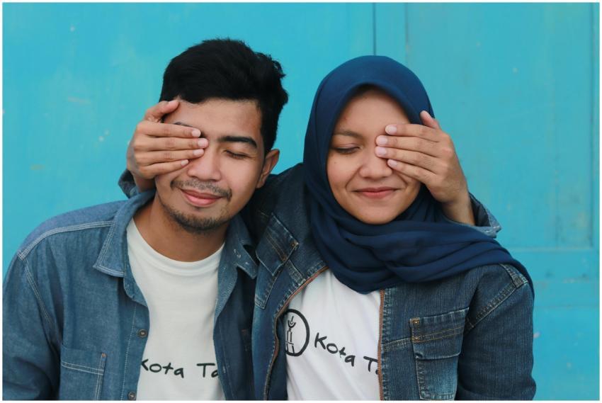 Happy young Asian couple wearing denim jackets pla