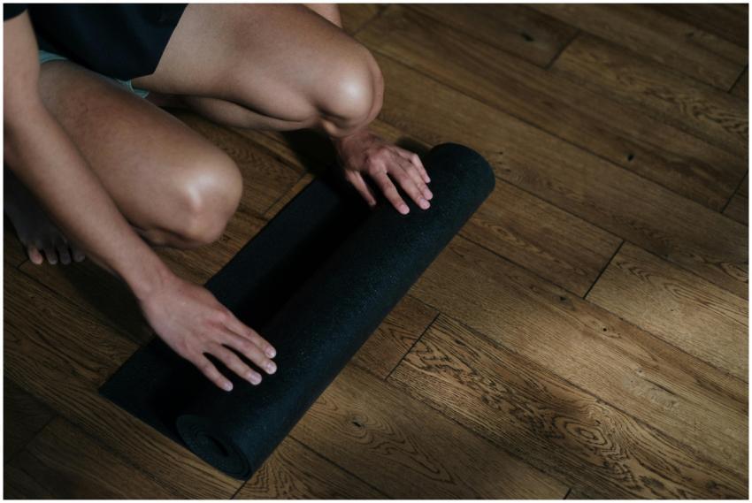 A man preparing for a yoga session by unrolling a