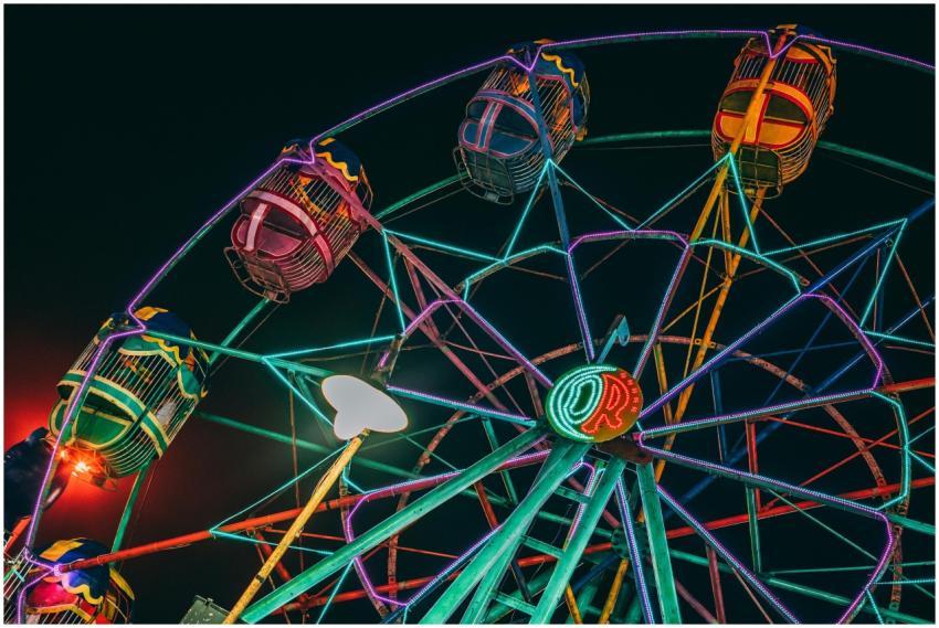 Colorful ferris wheel lit up against a dark night