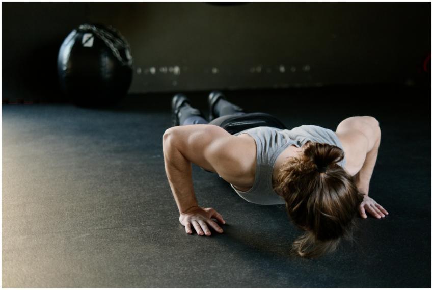 Strong male engaged in push-up exercise on gym flo