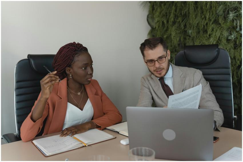 Two diverse professionals engage in a meeting, dis