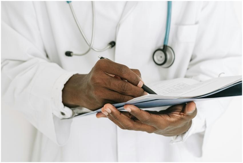 Professional doctor writing on a clipboard with a