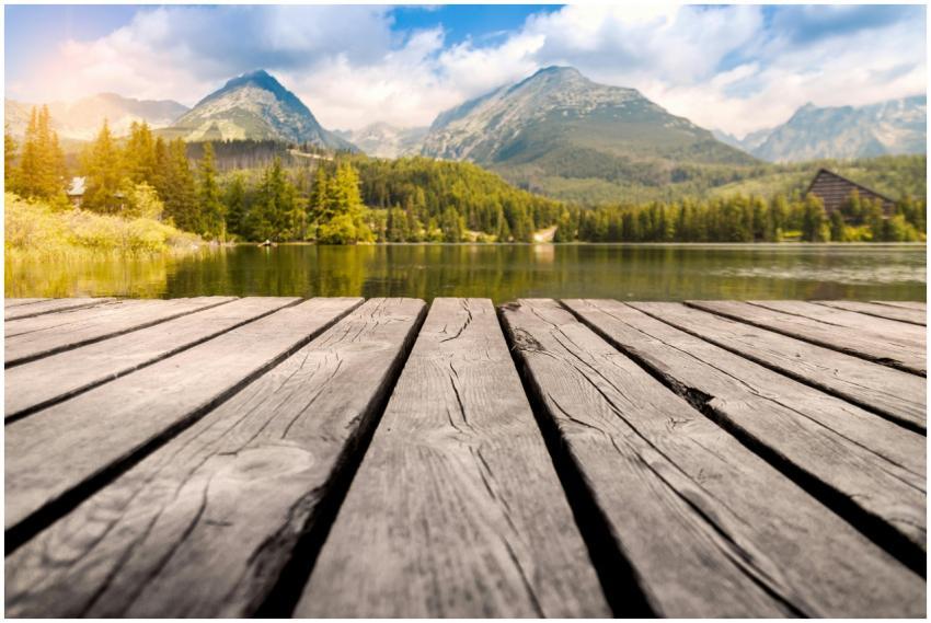 Calm mountain lake with a wooden dock, surrounded
