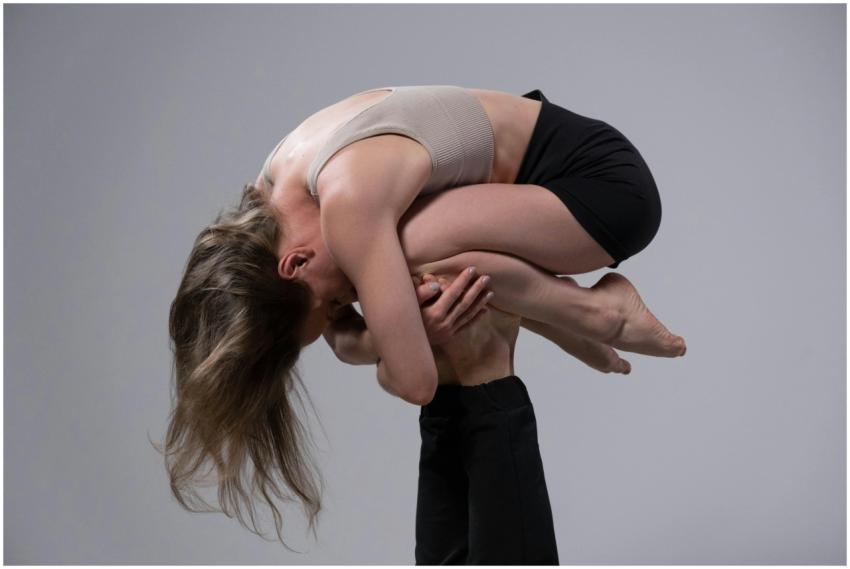 A powerful acrobatic pose with a woman supported b