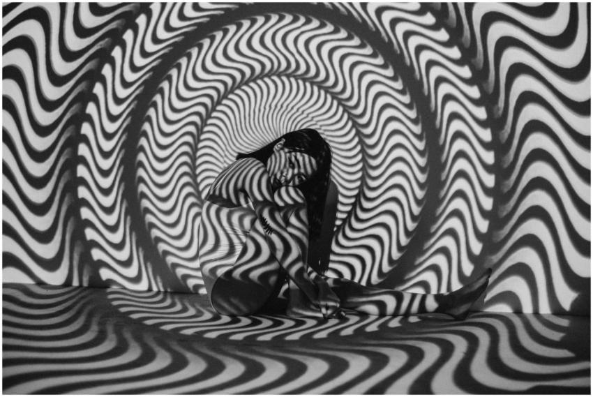 A woman enveloped in a trippy black and white opti