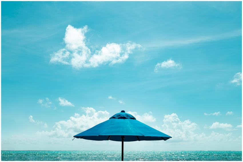 Blue parasol on a serene Caribbean beach under a c