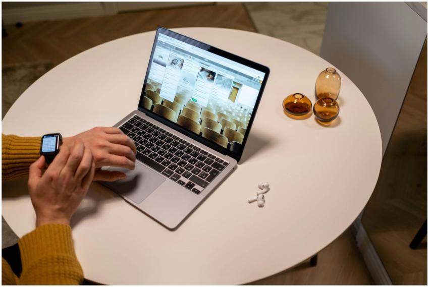 Person in yellow sweater working at a laptop with