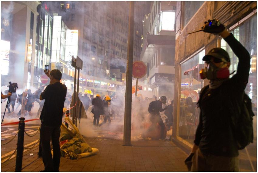 Nighttime street protest scene with smoke and crow