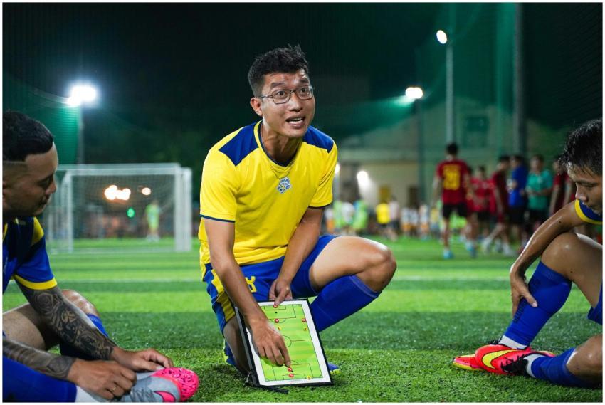 A soccer coach strategizing on a field with player