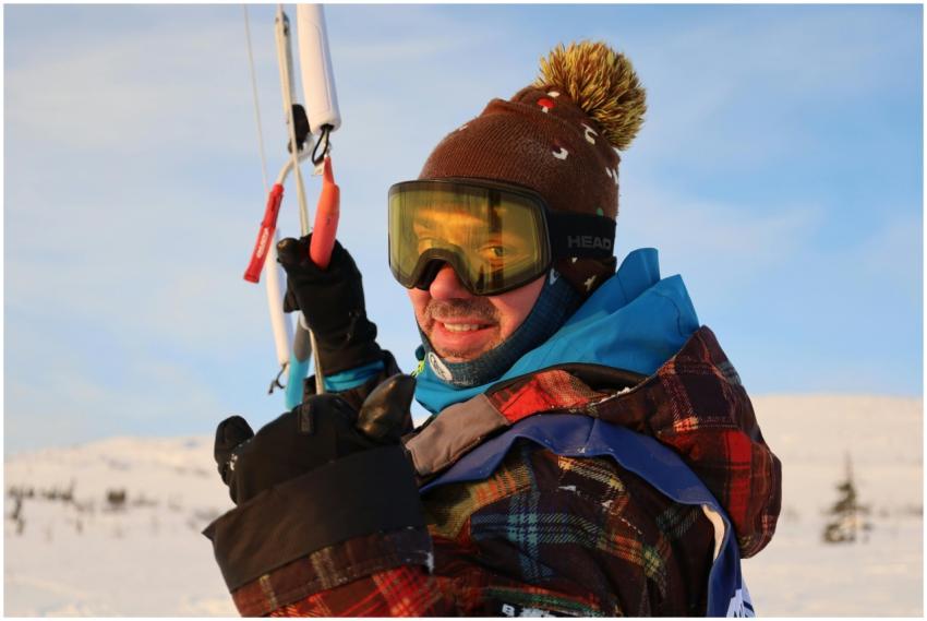 A man enjoying kiteboarding in a snowy winter land