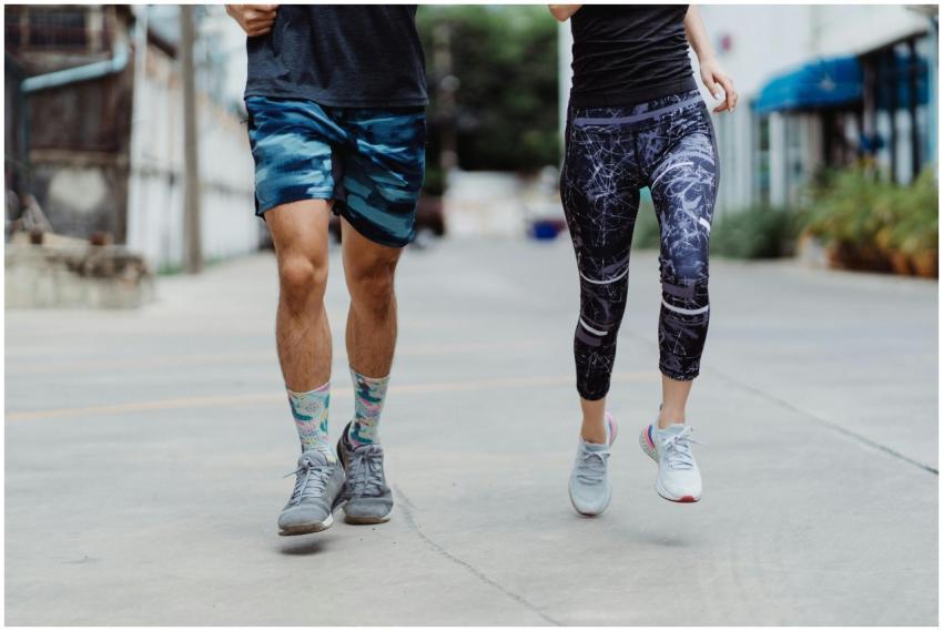 A fit couple jogging outdoors, showcasing vibrant
