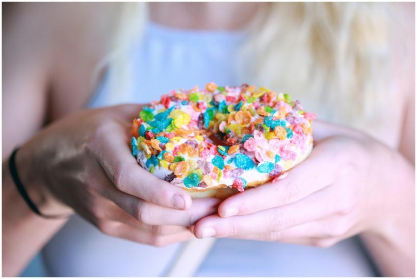 Delicious donut with colorful cereal topping being