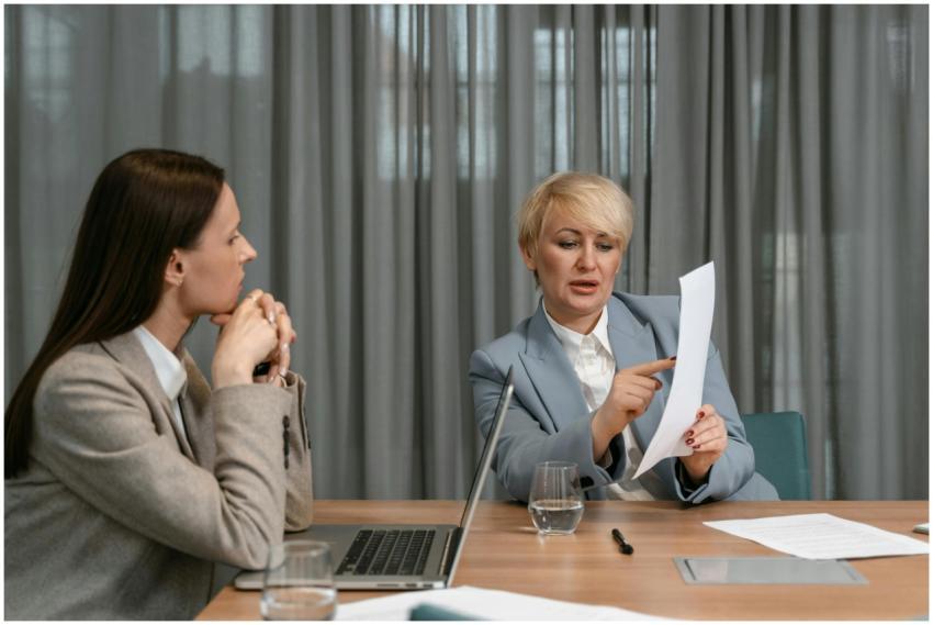 Two businesswomen discussing documents during a pr