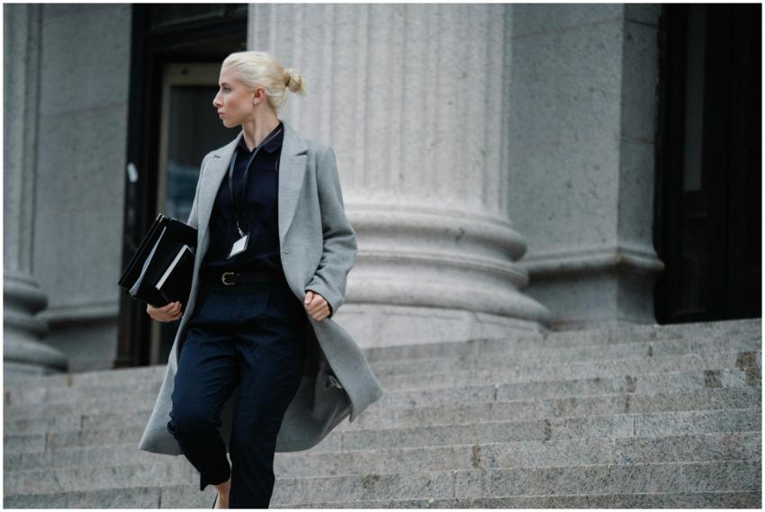 Serious female lawyer in elegant outfit holding fo