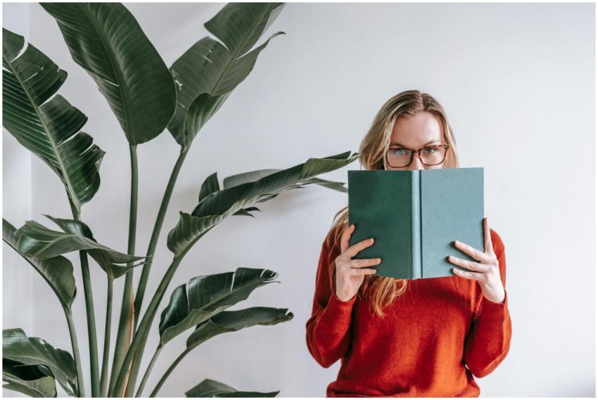 Caucasian woman reading a book with face partially